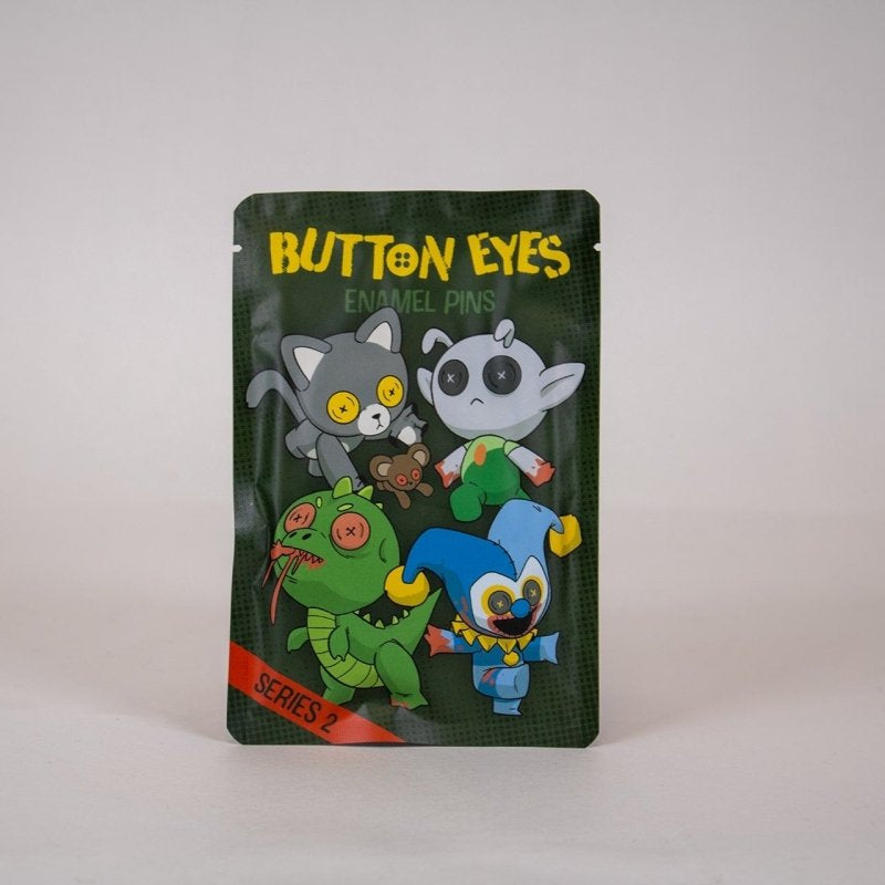 Packaged enamel pin blind bag with horror buttoneyes characters on a white background