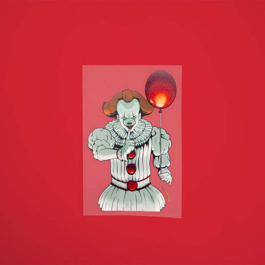 a 6-inch clown sticker with orange hair and white suit holding a red balloon