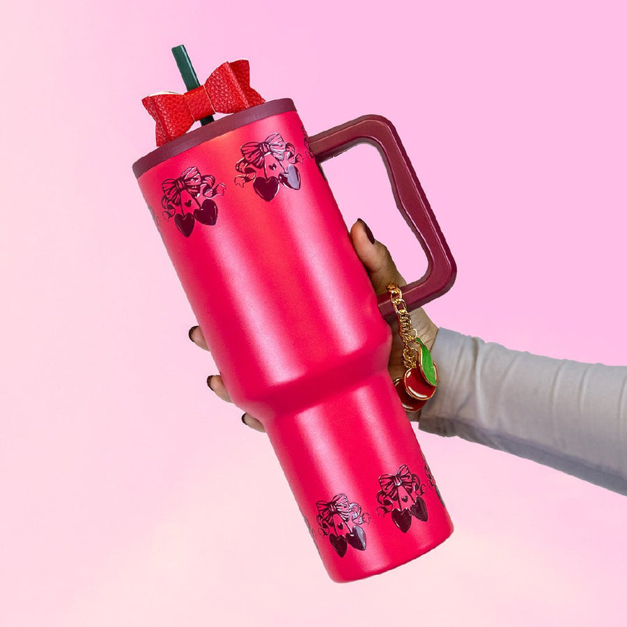 hand holding a cherry colored tumbler with cherry design on top and bottom