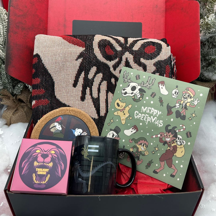 Gift set with a mug, card, coasters, and blanket in a box with a red interior.