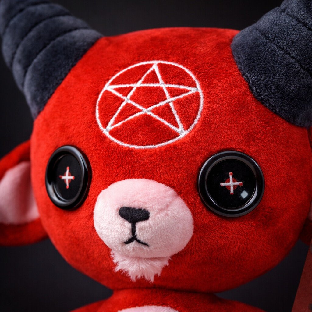 red devil goat with black button eyes and horns close up image