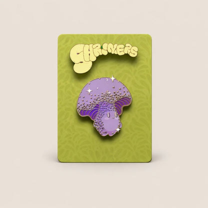 Purple mushroom-shaped enamel pin on a green card with 'Shroomers' branding.