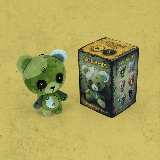 ButtonEyes plushie blind box packaging displayed with ButtonEyes green bear plushie on yellow textured background