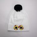 White beanie with black pom-pom and sunflower horror design on a light gray background