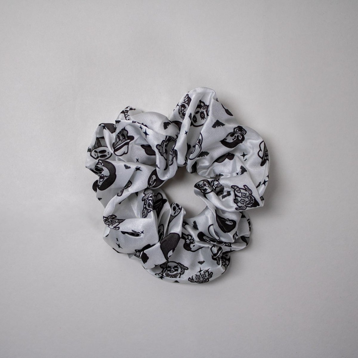 Black and white patterned  horror scrunchie on a gray background
